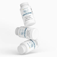 Colostrum Capsules, multiple bottles arranged artistically